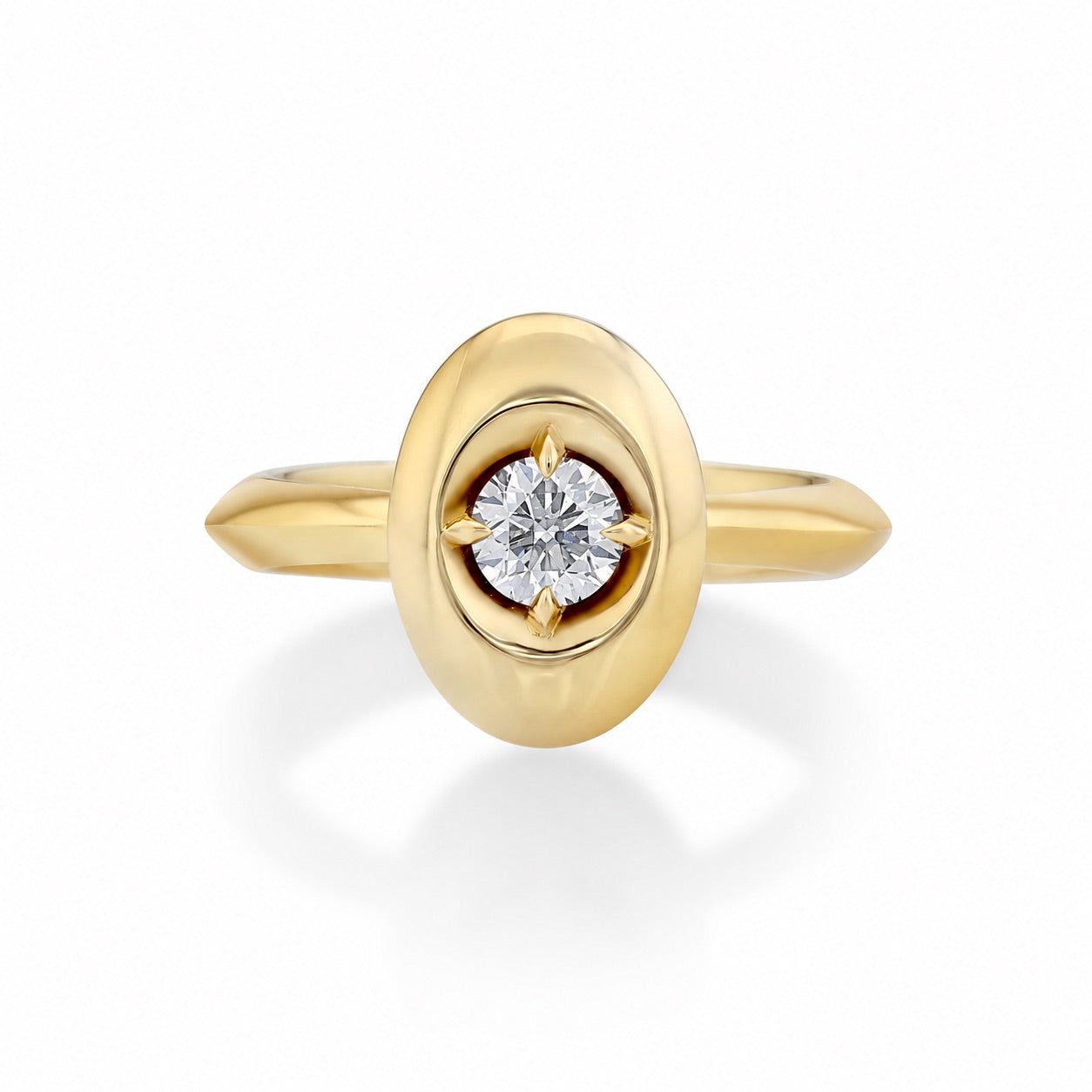 A yellow gold ring featuring an oval bezel-set diamond with a starburst prong setting and a polished band, shown on a clean white background.