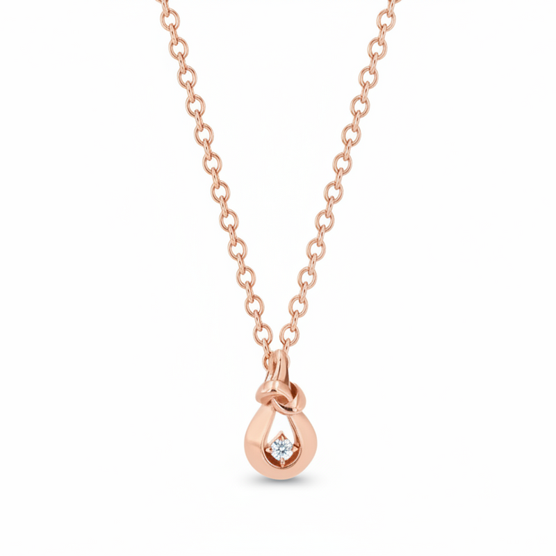 gold knot necklace with diamond on white background